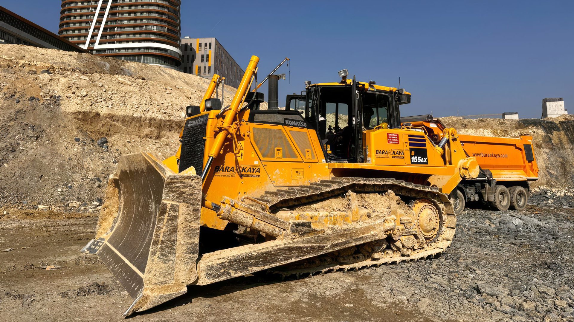 Yellow Komatsu bulldozer on a dirt construction site.
