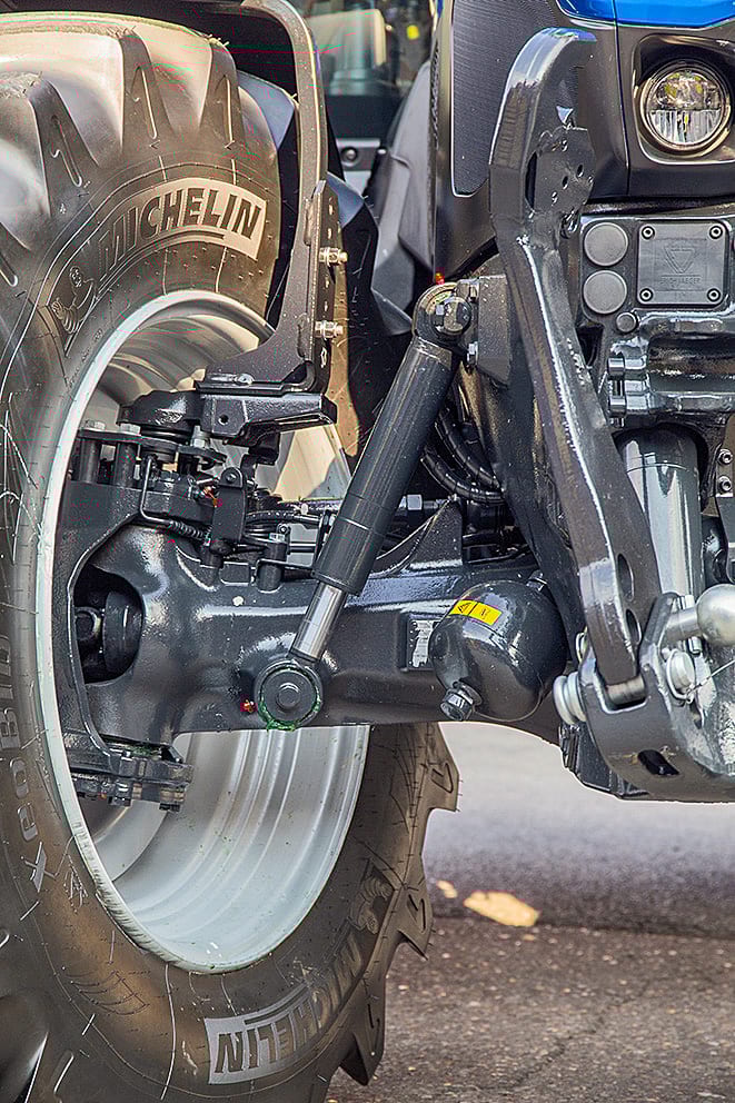 Close-up of a tractor's front wheel with a Michelin tire and visible suspension components.