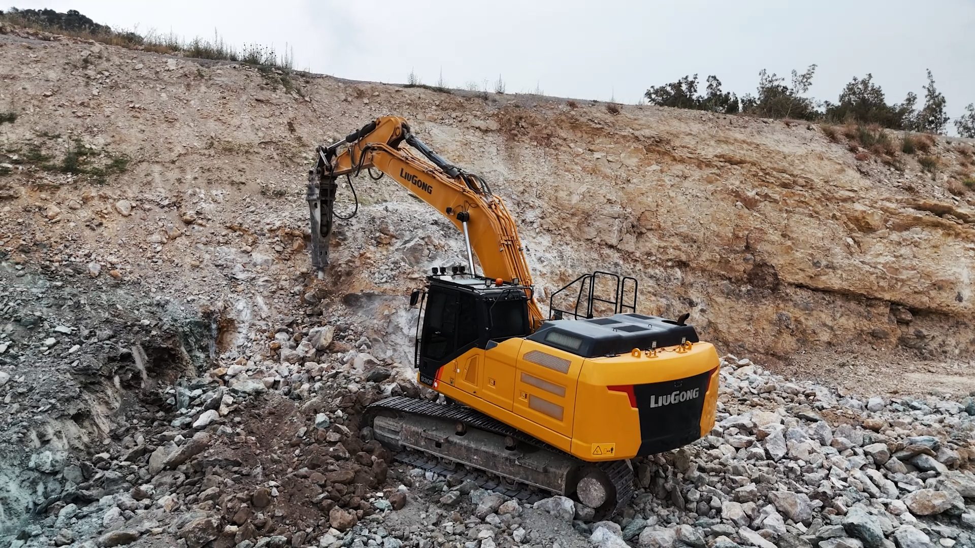 LiuGong excavator with breaker breaking rock in a quarry.