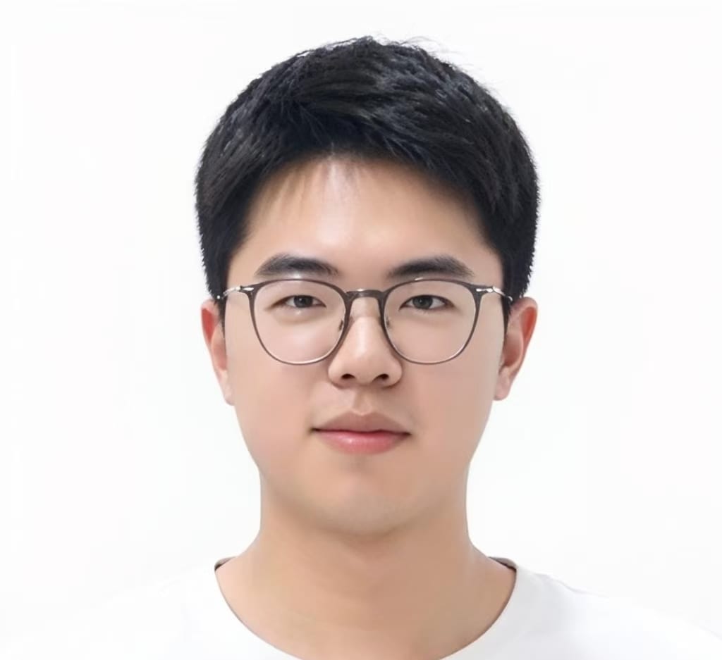 Close-up of a young East Asian man wearing glasses.