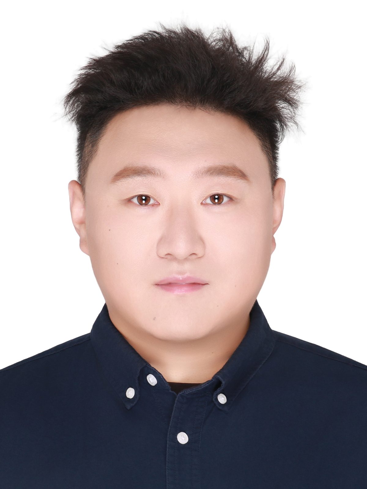 Headshot of a man with short, spiky dark hair and a neutral expression, wearing a dark blue shirt on white.