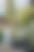 A person in a light shirt and shorts walks through a lush desert garden filled with diverse cacti and agaves.