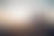 Two people sit on a fence, watching the sunset over the ocean. A peaceful beach scene.