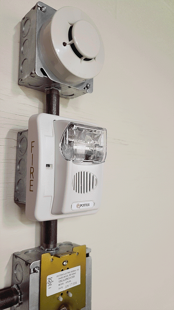 Pictured is a typical notification appliance installed in conjunction with the required smoke detector and manual pull station at a buildings fire sprinkler riser.