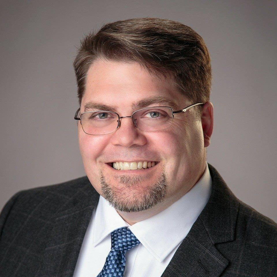 Headshot, Dress shirt, Forehead, Glasses, Smile, Chin, Eyebrow, Tie, Beard, Jaw