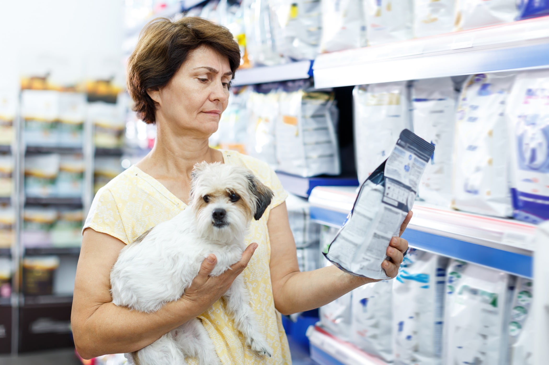 Woman in store with dog buying pet food
