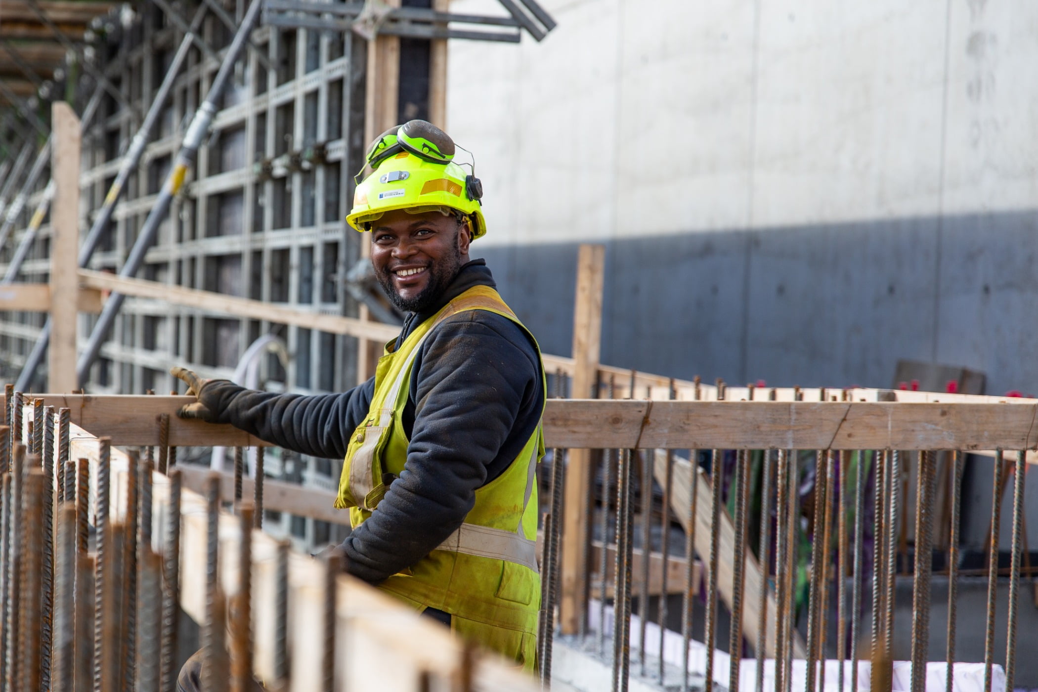 Hard hat, High-visibility clothing, Outerwear, Workwear, Helmet, Tradesman, Engineer, Fence, Smile, Yellow